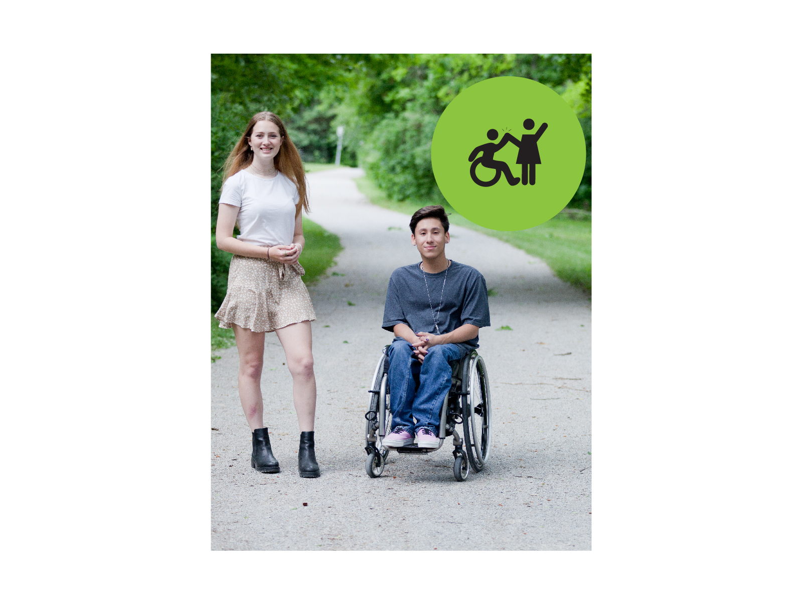 Teenager with long hair wearing a white t-shirt and skirt standing next to a teenager with short hair wearing a grey tshirt and jeans in a wheelchair. They are outside in a park. Small green circle icon with graphic of person in a wheelchair high-fiving a person that is standing.