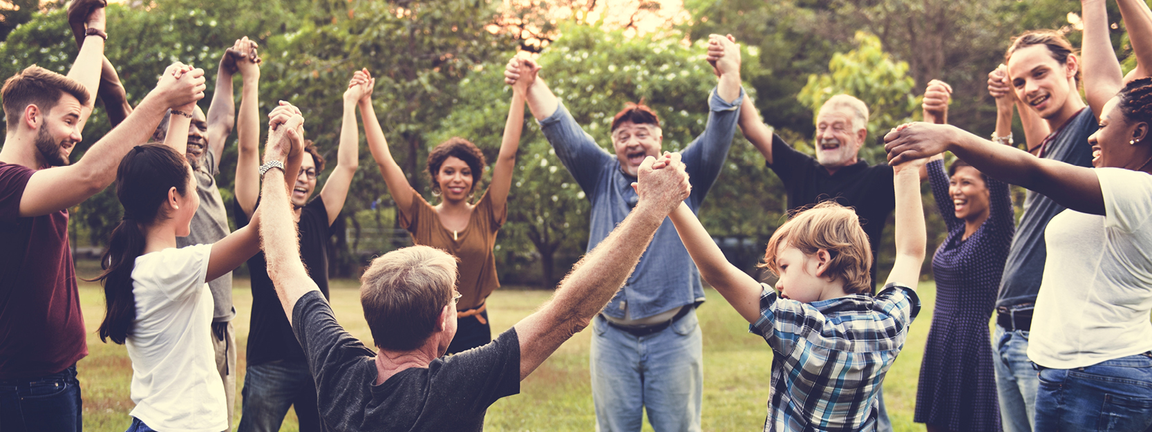 group with raised clasped hands in a circle outdoors