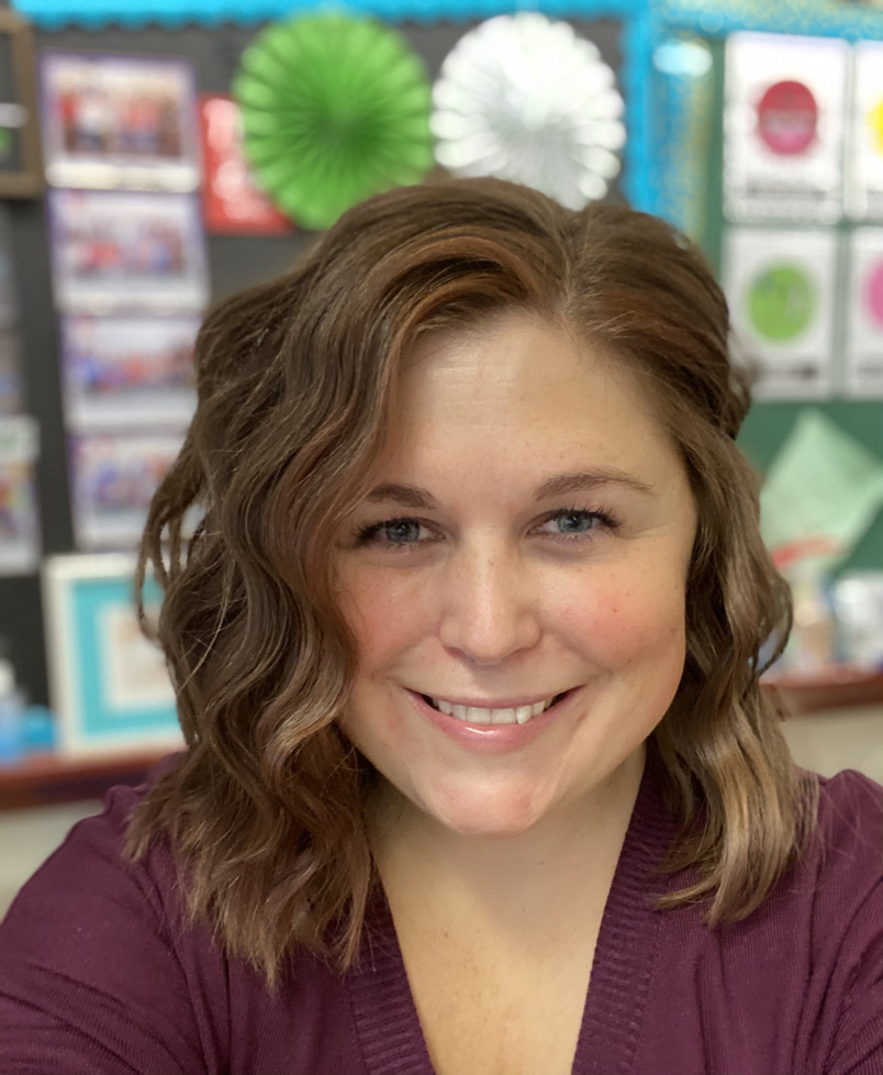 selfie of a woman with short brown hair in a classroom