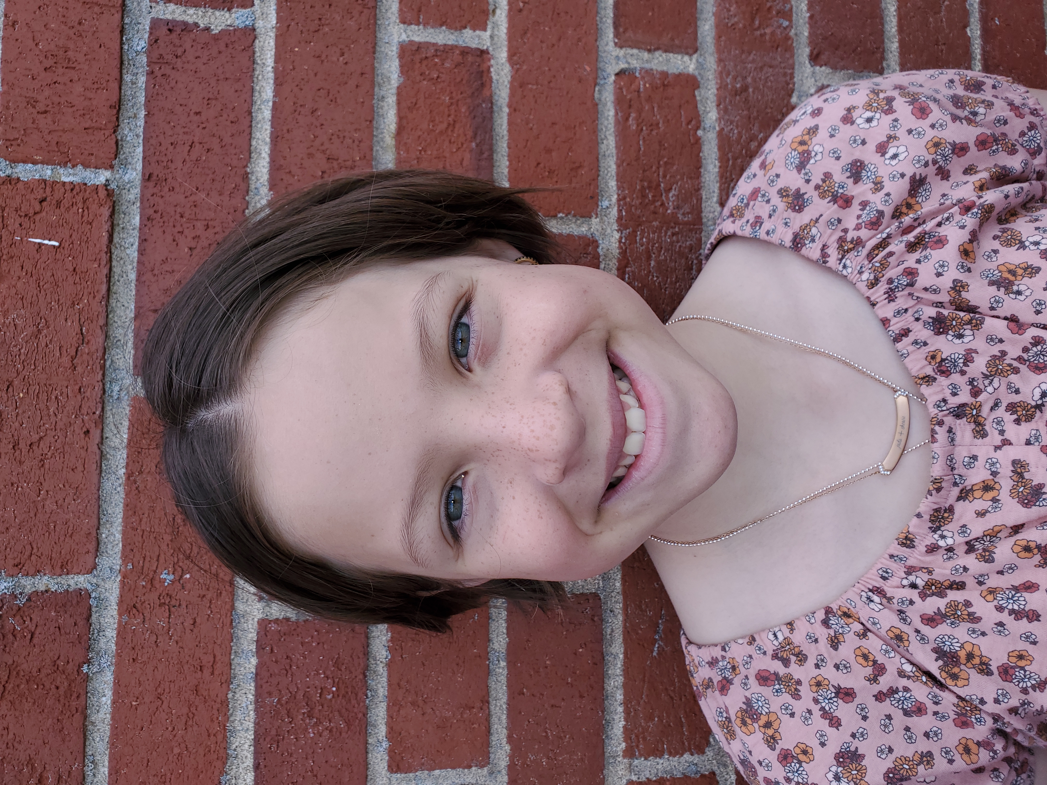 girl standing next to a brick wall